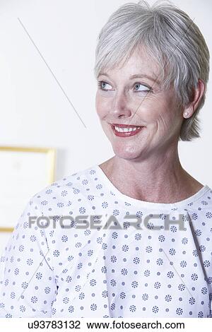 USA, California, Fairfax, Smiling woman in hospital gown sitting in doctor's office View Large Photo Image Stock Image - USA, California, Fairfax, Smiling woman in hospital gown sitting in doctor's office. Fotosearch