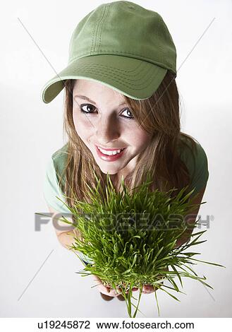 USA California, Fairfax, studio portrait of smiling young woman holding wheat grass View Large Photo Image Stock Image - USA California, Fairfax, studio portrait of smiling young woman holding wheat grass. Fotosearch