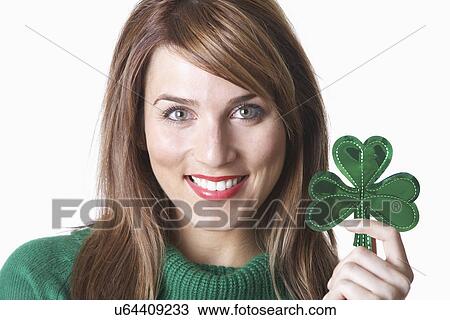 USA California, Fairfax, studio portrait of young woman holding shamrock View Large Photo Image Stock Image - USA California, Fairfax, studio portrait of young woman holding shamrock. Fotosearch