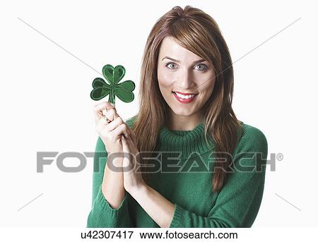 USA California, Fairfax, studio portrait of young woman holding shamrock View Large Photo Image Stock Photo - USA California, Fairfax, studio portrait of young woman holding shamrock. Fotosearch