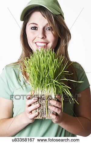 USA California, Fairfax, studio portrait of smiling young woman holding wheat grass View Large Photo Image Stock Photo - USA California, Fairfax, studio portrait of smiling young woman holding wheat grass. Fotosearch