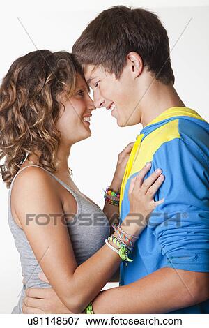 Stock Photo - USA, California, Fairfax, Teen (14-17) couple embracing, against white background. Fotosearch