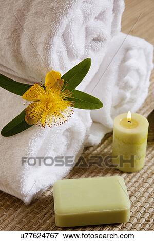 Stock Photo - USA, California, Fairfax, Towels with flower and burning candle in health spa. Fotosearch