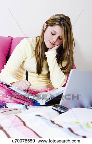 USA, California, Fairfax, young woman doing homework on bed View Large Photo Image Stock Photo - USA, California, Fairfax, young woman doing homework on bed. Fotosearch