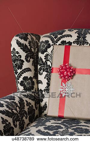 Stock Photo - USA, California, La Quinta, Christmas present on sofa. Fotosearch