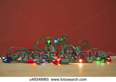 Stock Photography - USA, California, La Quinta, Christmas lights against red background. Fotosearch