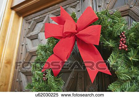 Stock Photography - USA, California, La Quinta, Christmas wreath on wooden doors. Fotosearch