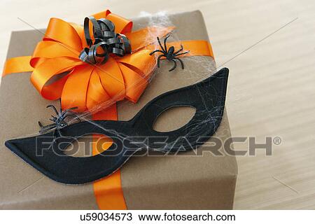 Stock Image - USA, California, La Quinta, Halloween gift with spiders and mask. Fotosearch