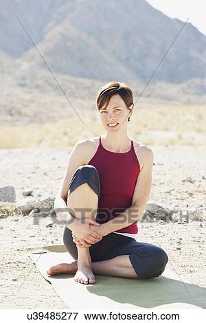 USA, California, La Quinta, Portrait of woman sitting on exercise mat in desert landscape View Large Photo Image Stock Photo - USA, California, La Quinta, Portrait of woman sitting on exercise mat in desert landscape. Fotosearch