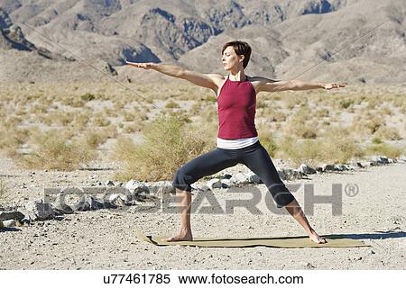 USA, California, La Quinta, Woman standing in yoga warrior pose in desert landscape View Large Photo Image Stock Photography - USA, California, La Quinta, Woman standing in yoga warrior pose in desert landscape. Fotosearch