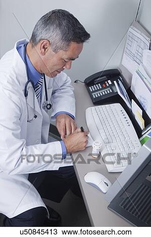 USA California, Larkspur, Doctor writing prescription at desk View Large Photo Image Stock Image - USA California, Larkspur, Doctor writing prescription at desk. Fotosearch