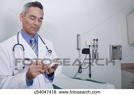 Stock Photo - USA California, Larkspur, Doctor writing prescription in office. Fotosearch