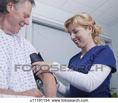USA California, Larkspur, Smiling nurse taking patient's blood pressure View Large Photo Image Picture - USA California, Larkspur, Smiling nurse taking patient's blood pressure. Fotosearch