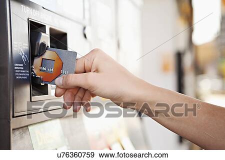 Stock Photo - USA, California, Lawndale, Female hand inserting card into tam. Fotosearch