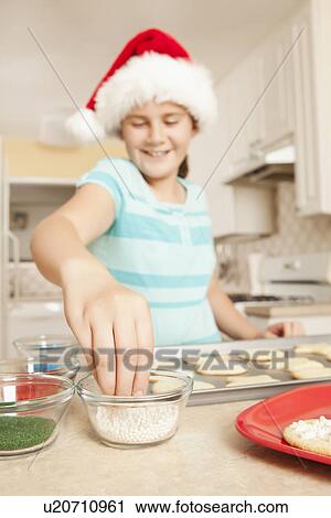 USA, California, Lawndale, Girl (10-11) wearing santa hat topping cookies with sprinkles View Large Photo Image Stock Image - USA, California, Lawndale, Girl (10-11) wearing santa hat topping cookies with sprinkles. Fotosearch