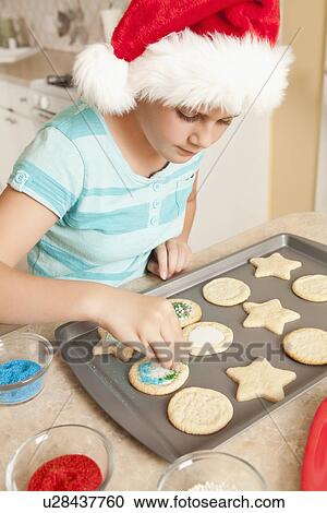 USA, California, Lawndale, Girl (10-11) wearing santa hat topping cookies with sprinkles View Large Photo Image Stock Image - USA, California, Lawndale, Girl (10-11) wearing santa hat topping cookies with sprinkles. Fotosearch