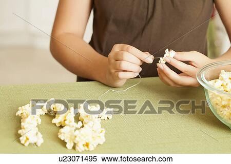 USA, California, Lawndale, Midsection of girl (10-11) sewing popcorn onto string View Large Photo Image Stock Photography - USA, California, Lawndale, Midsection of girl (10-11) sewing popcorn onto string. Fotosearch