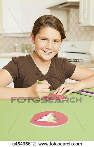 Stock Image - USA, California, Lawndale, Portrait of girl (10-11) preparing holiday decoration. Fotosearch