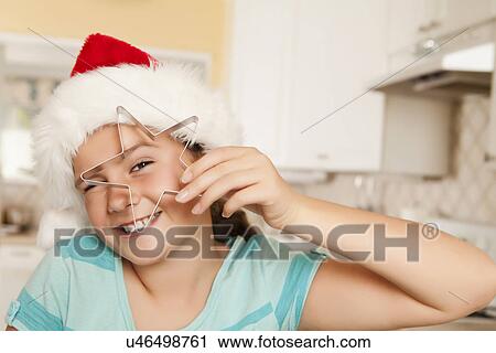 USA, California, Lawndale, Portrait of girl (10-11) wearing santa hat holding pastry cutter View Large Photo Image Stock Image - USA, California, Lawndale, Portrait of girl (10-11) wearing santa hat holding pastry cutter. Fotosearch