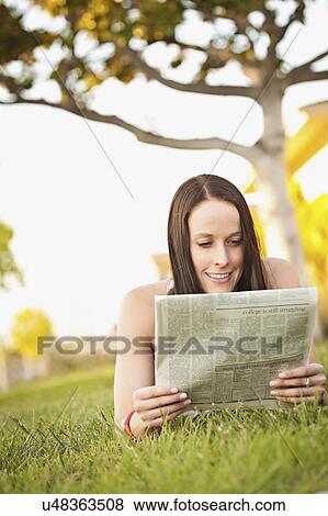 USA, California, Lawndale, Woman lying on grass reading newspaper View Large Photo Image Stock Photo - USA, California, Lawndale, Woman lying on grass reading newspaper. Fotosearch