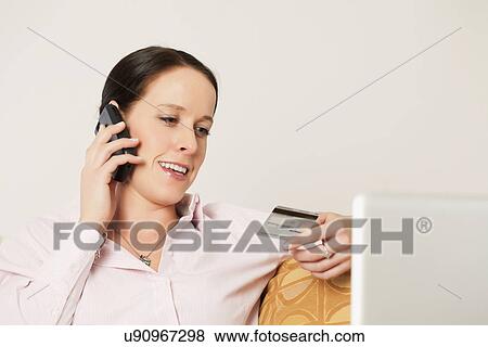 USA, California, Lawndale, Woman holding credit card and talking on phone View Large Photo Image Stock Photo - USA, California, Lawndale, Woman holding credit card and talking on phone. Fotosearch