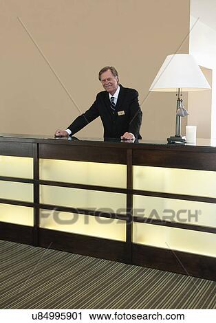 Stock Image - USA, California, Mill Valley, Concierge behind counter. Fotosearch