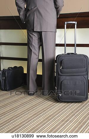 Stock Photo - USA, California, Mill Valley, Businessman waiting at hotel reception. Fotosearch