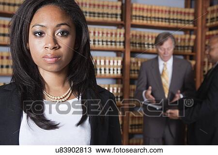 Stock Image - USA, California, Oakland, Business people in library, focus on woman. Fotosearch