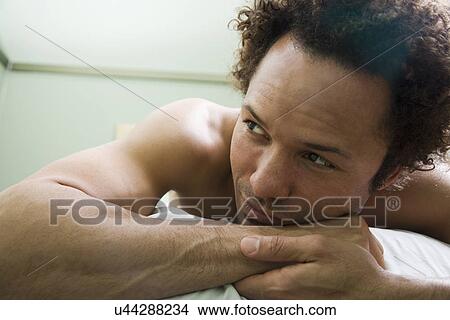 Picture - USA, California, Oakland, man lying on massage bed. Fotosearch