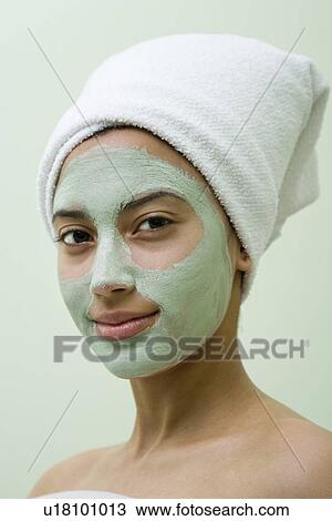 Stock Image - USA, California, Oakland, portrait of smiling young woman with facial mask. Fotosearch