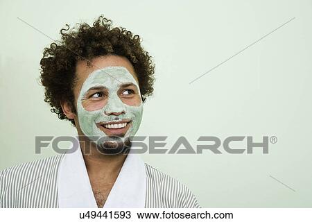 Stock Image - USA, California, Oakland, portrait of smiling man with facial mask. Fotosearch