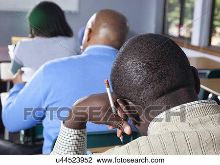 Stock Image - USA, California, Oakland, Students writing exam. Fotosearch