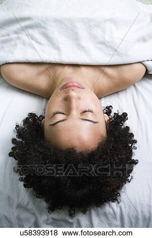 Stock Photo - USA, California, Oakland, young woman lying on massage bed. Fotosearch