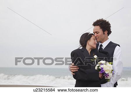 Picture - USA, California, San Francisco, Baker Beach, bride and groom on beach. Fotosearch