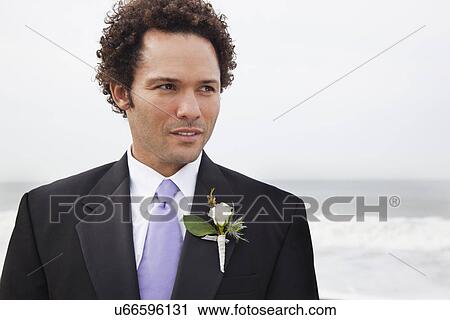Stock Image - USA, California, San Francisco, Baker Beach, portrait of groom on beach. Fotosearch