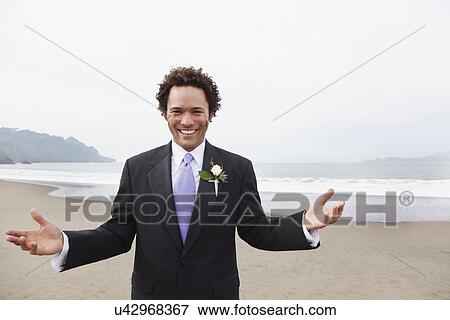 Stock Photo - USA, California, San Francisco, Baker Beach, portrait of groom on beach. Fotosearch