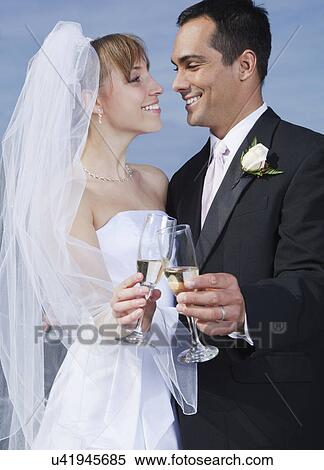 Stock Photography - USA, California, San Francisco, bride and groom holding champagne. Fotosearch