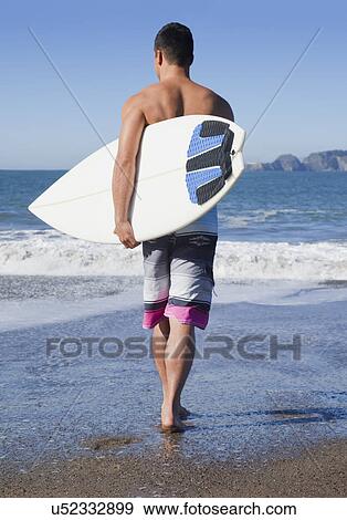 USA, California, San Francisco, man carrying surfboard on Baker Beach View Large Photo Image Stock Photo - USA, California, San Francisco, man carrying surfboard on Baker Beach. Fotosearch