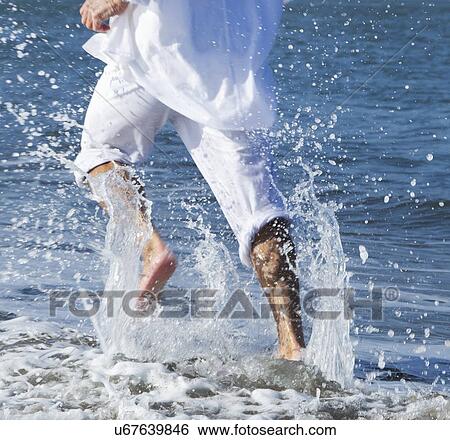 Stock Photograph - USA, California, San Francisco, Man jogging on beach. Fotosearch
