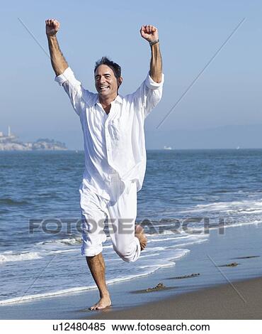 Stock Photography - USA, California, San Francisco, Man jogging on beach. Fotosearch