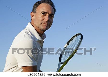 Stock Photo - USA, California, San Francisco, Mature man playing tennis. Fotosearch