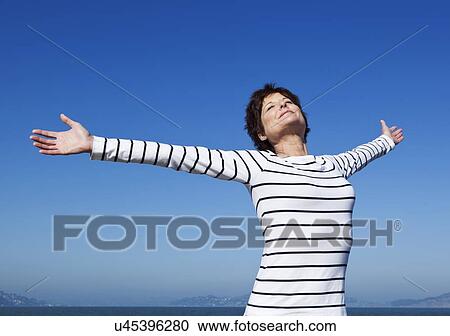 Stock Image - USA, California, San Francisco, Portrait of woman against blue sky. Fotosearch