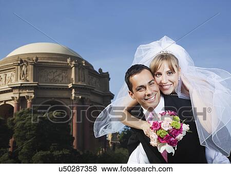 Stock Photo - USA, California, San Francisco, portrait of bride and groom embracing. Fotosearch