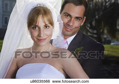 Stock Photograph - USA, California, San Francisco, portrait of bride and groom embracing. Fotosearch