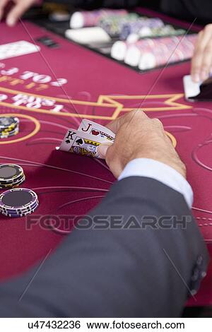 Stock Photograph - USA, California, Stockton, Man playing poker in casino, close-up of hand. Fotosearch