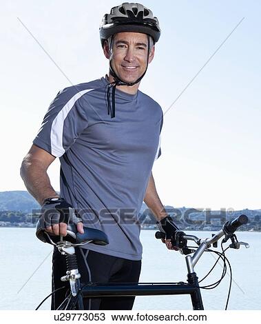 Stock Image - USA, California, Tiburon, Cyclist at lakeside. Fotosearch