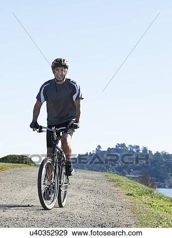 Stock Photo - USA, California, Tiburon, Cyclist at lakeside. Fotosearch