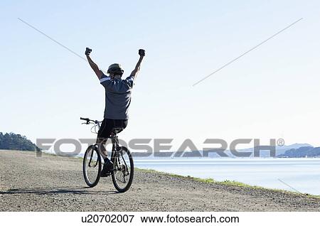 Stock Photo - USA, California, Tiburon, Cyclist on lakeside. Fotosearch