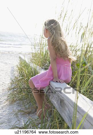 USA, Florida, St. Pete Beach, Girl (8-9) sitting on wooden rail on beach View Large Photo Image Picture - USA, Florida, St. Pete Beach, Girl (8-9) sitting on wooden rail on beach. Fotosearch