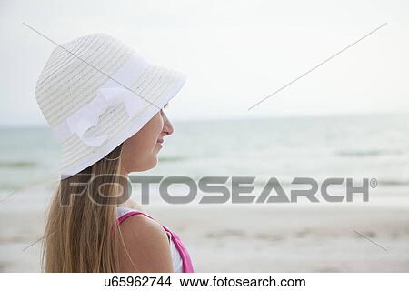 Picture - USA, Florida, St. Pete Beach, Girl (8-9) in sun hat on beach. Fotosearch